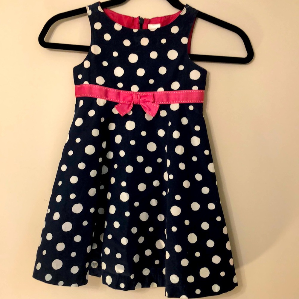 Sleeveless navy blue dot dress with pink ribbon